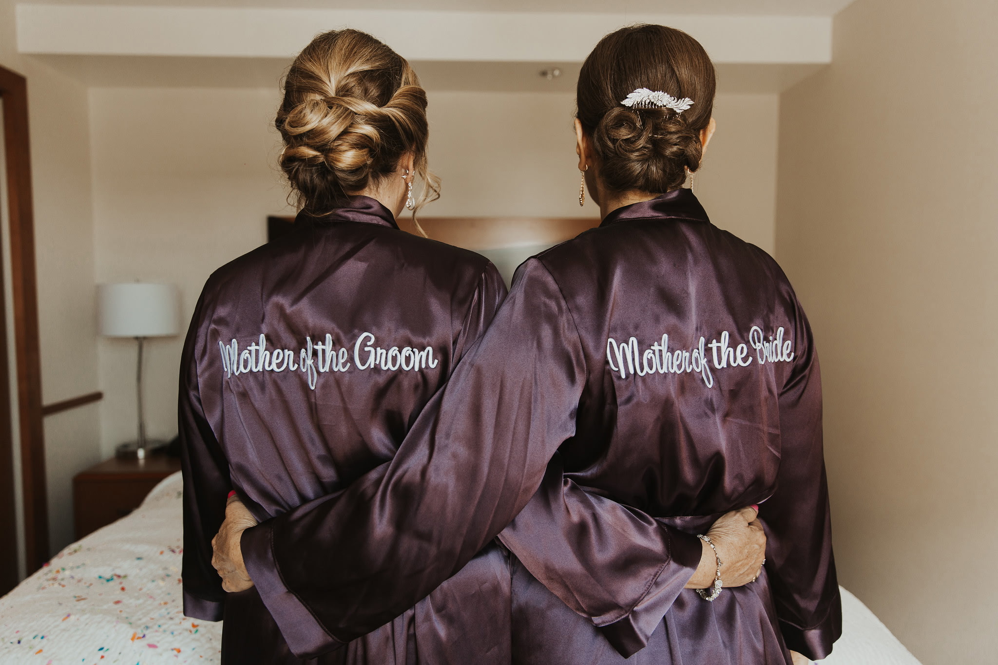 Mother of the groom and mother of the bride showcasing elegant wedding updos styled for a special occasion